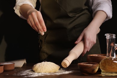 Photo of Woman making grissini at wooden table, closeup