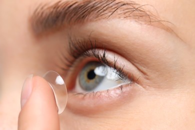 Woman putting in contact lens, closeup view