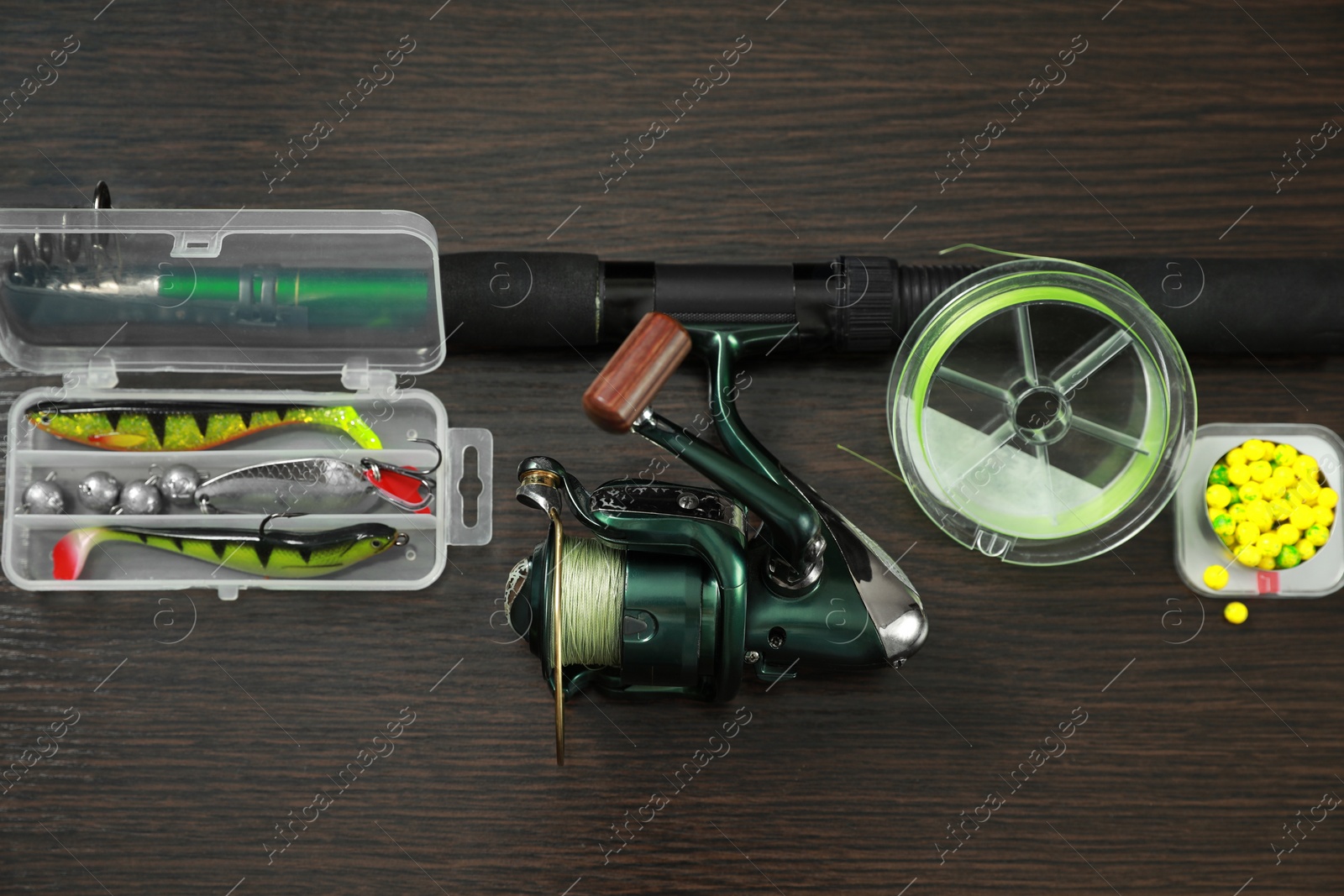 Photo of Fishing tackle on dark wooden background, above view