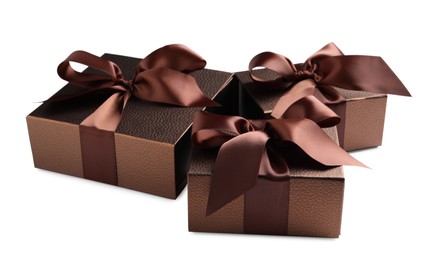 Photo of Brown gift boxes decorated with satin ribbon and bows on white background