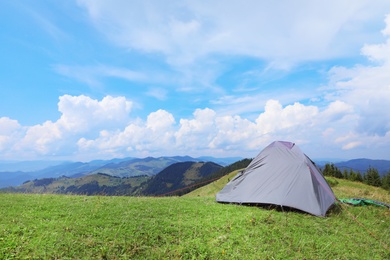 Photo of Small camping tent in mountains on sunny day