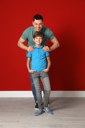Portrait of dad and his son near color wall