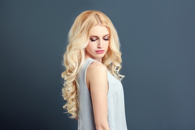 Portrait of young model with beautiful  hair on grey background