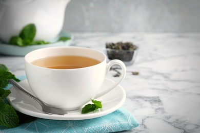 Photo of Fresh tea with mint on white marble table. Space for text