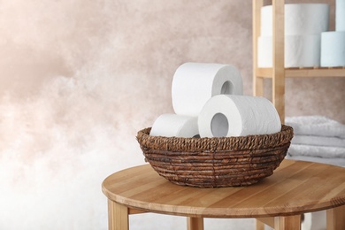 Bowl with toilet paper rolls on table indoors. Space for text