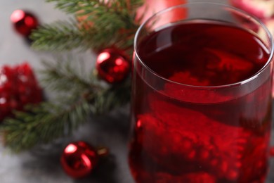 Photo of Aromatic Christmas Sangria drink in glass on table, closeup. Space for text