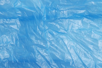 Photo of Crumpled light blue plastic bag as background, top view