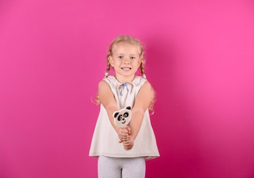 Photo of Cute little girl with candy on color background