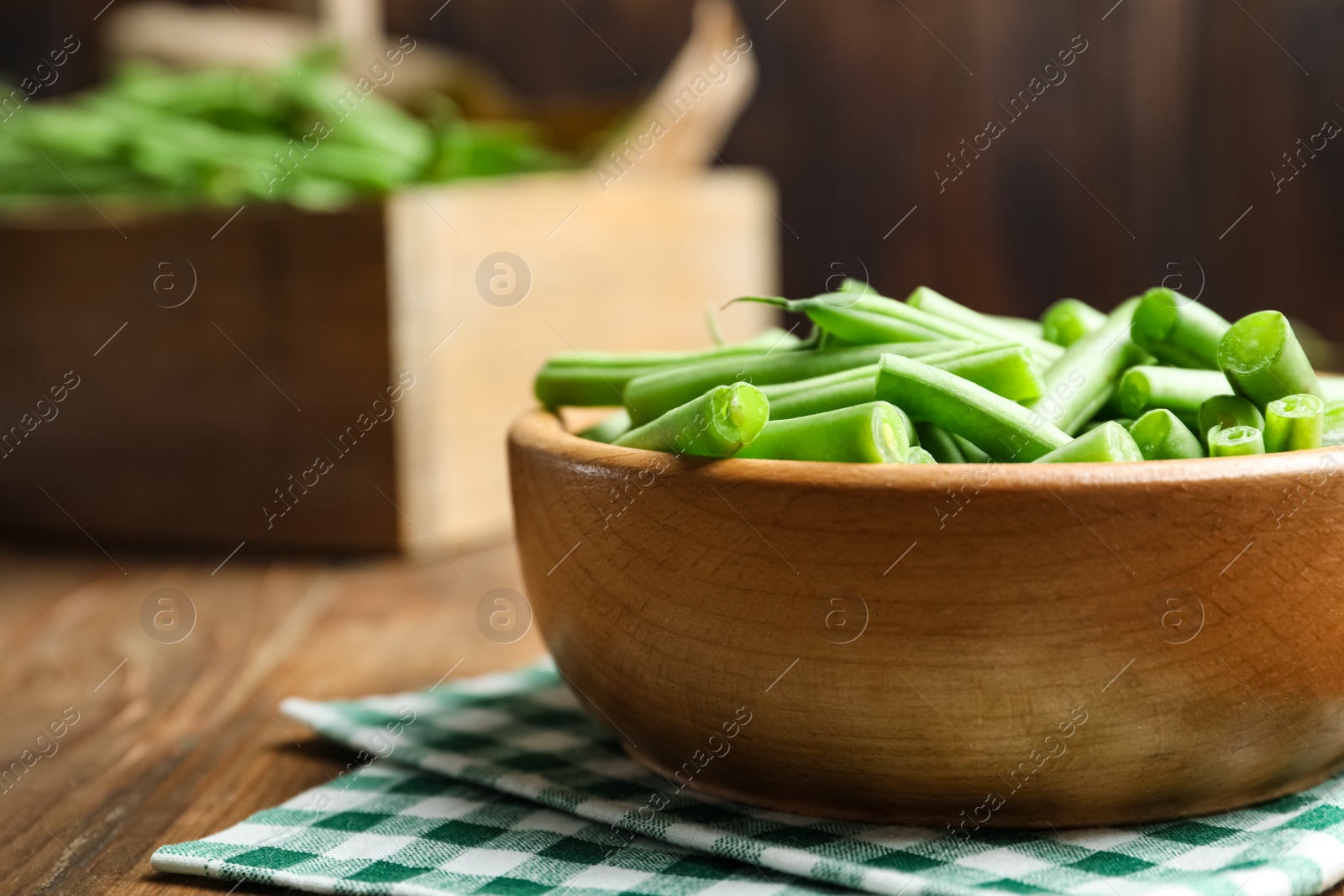 Photo of Fresh green beans in bowl on wooden table, closeup. Space for text