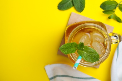 Photo of Delicious iced tea with mint on yellow background, flat lay. Space for text