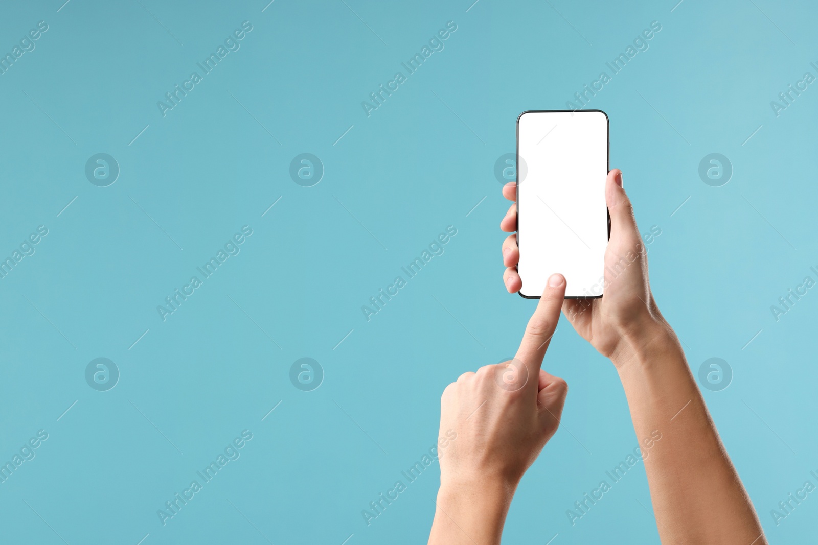 Photo of Man using smartphone with blank screen on light blue background, closeup. Mockup for design