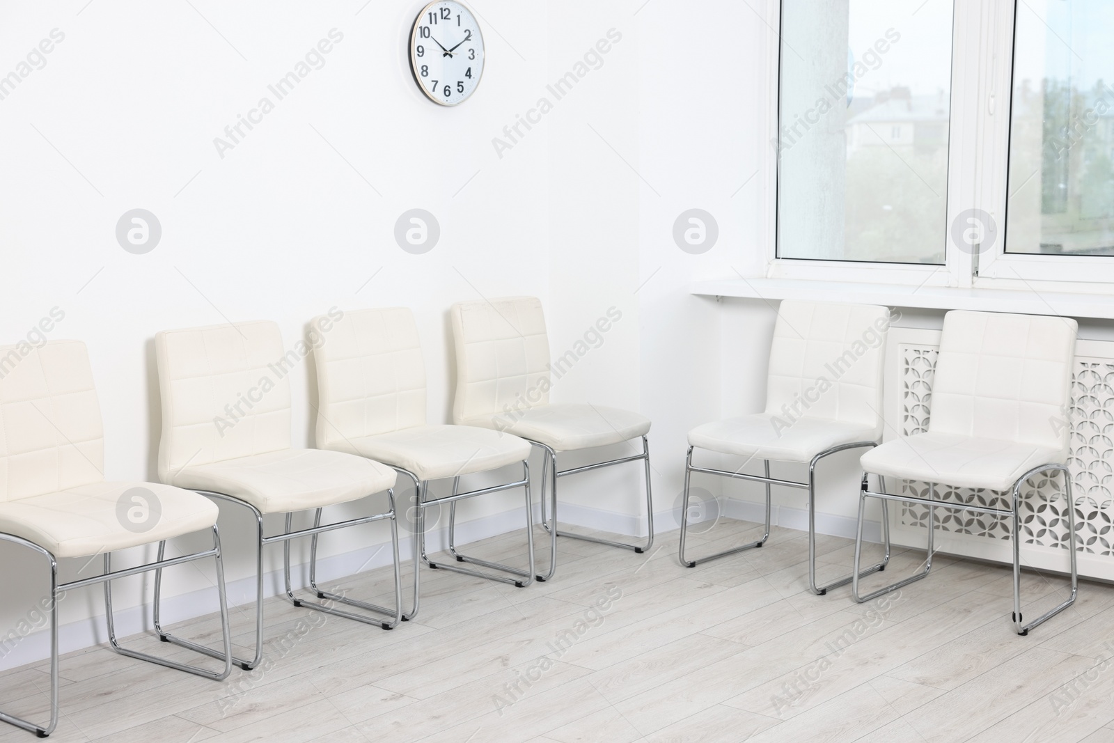 Photo of Many chairs near white wall in waiting area indoors