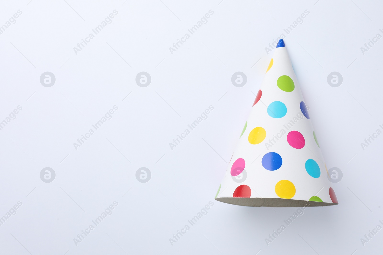 Photo of One beautiful party hat on light background, top view. Space for text