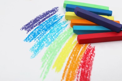 Photo of Colorful pastel chalks and scribbles on white background. Drawing materials