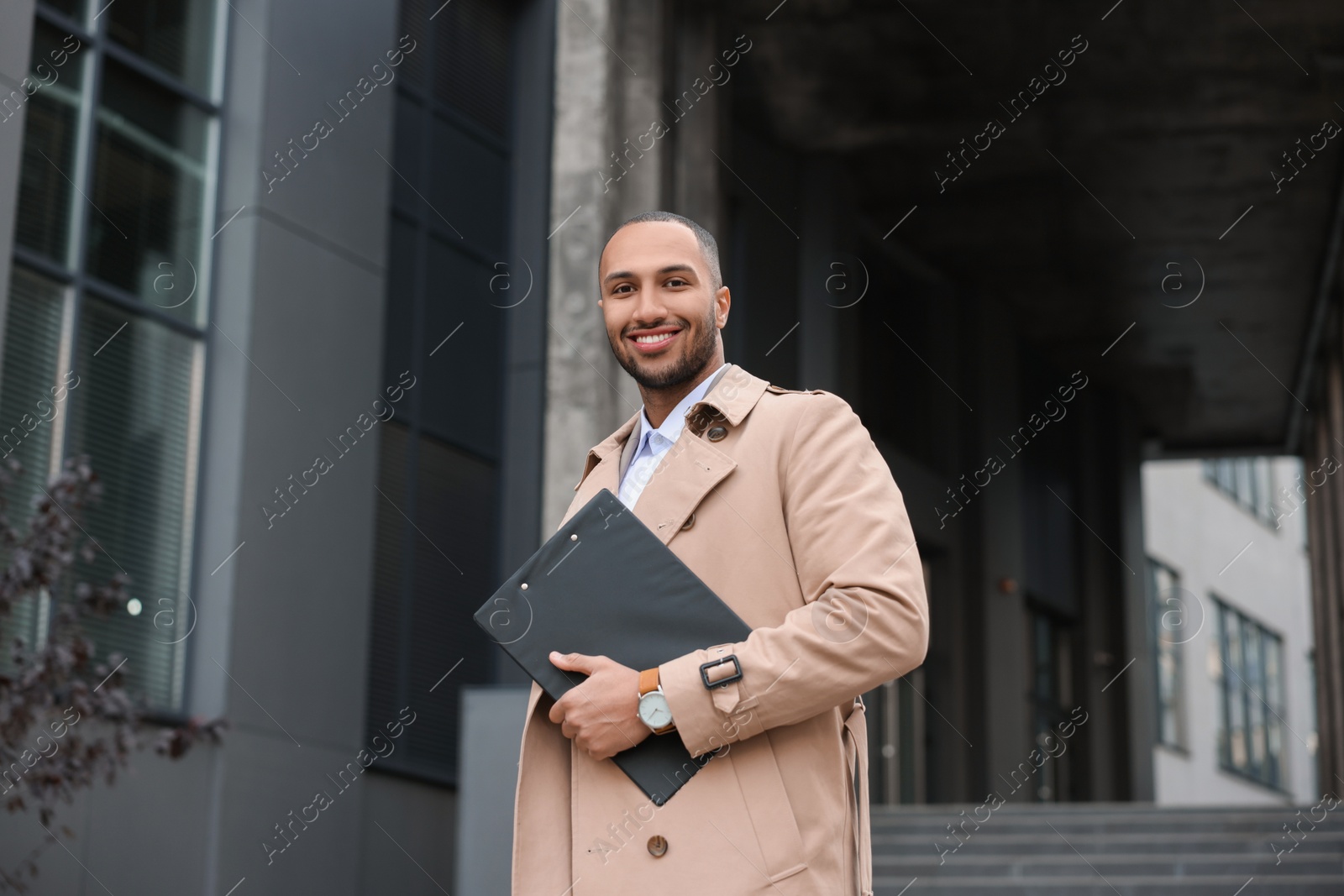 Photo of Happy man with clipboard outdoors. Lawyer, businessman, accountant or manager