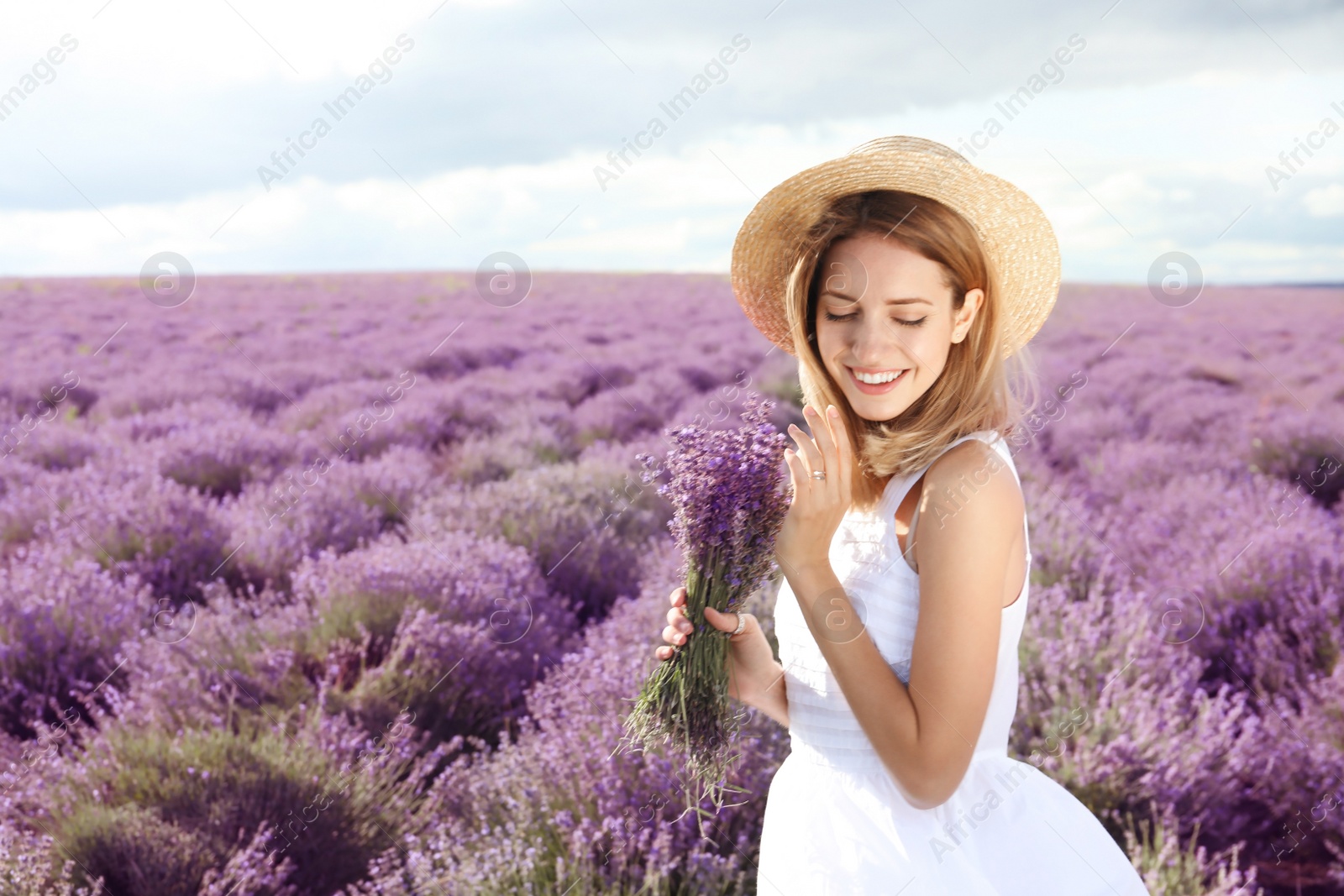 Photo of Young woman with bouquet in lavender field