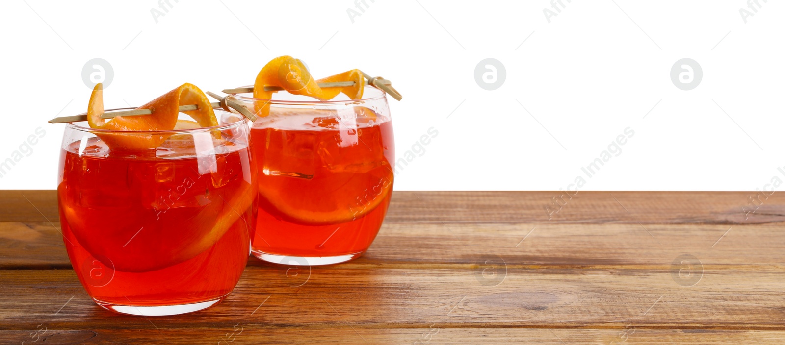 Photo of Aperol spritz cocktail and orange slices in glasses on wooden table against white background