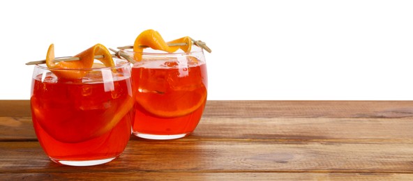 Photo of Aperol spritz cocktail and orange slices in glasses on wooden table against white background