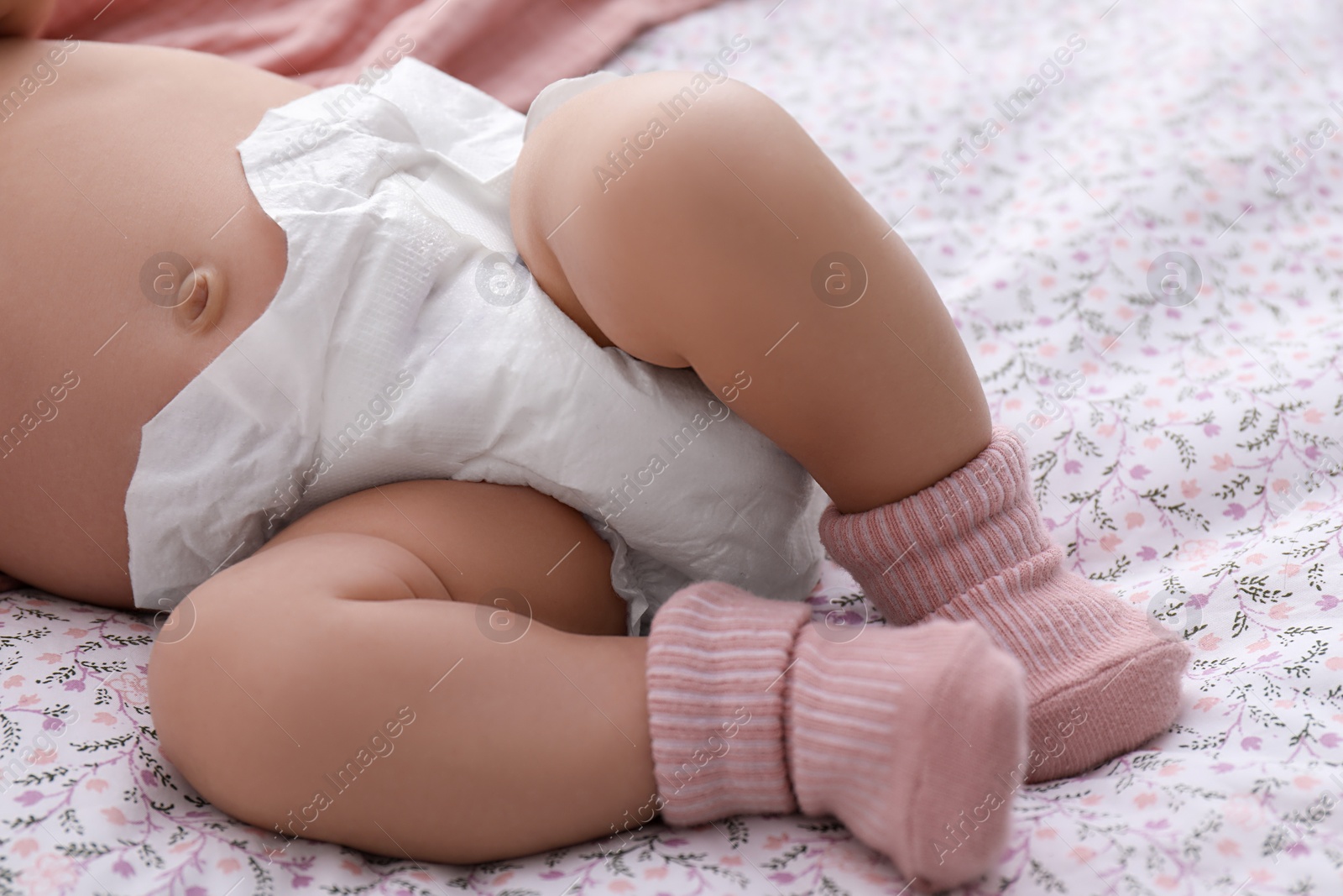 Photo of Little baby in diaper on bed, closeup