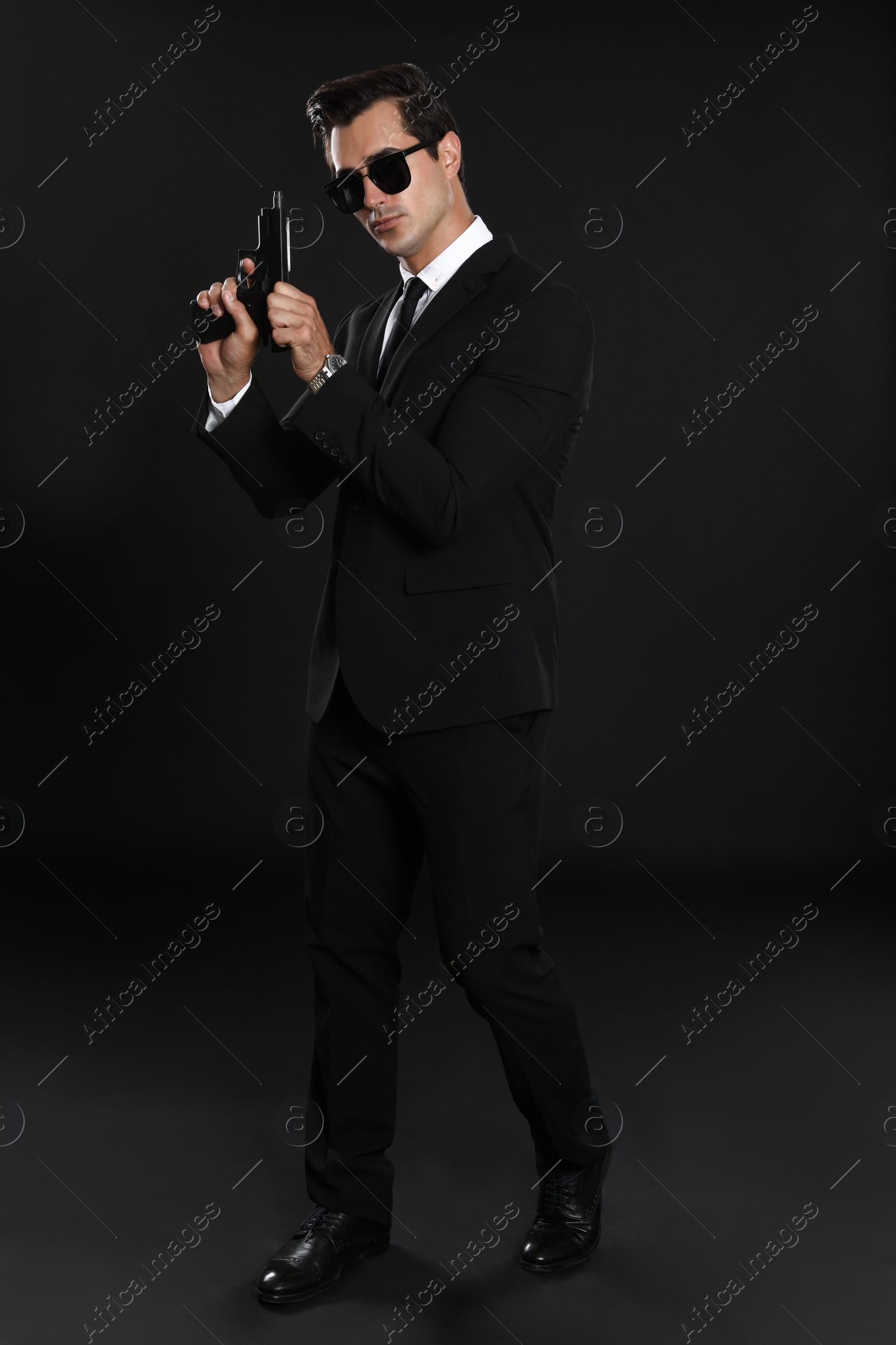 Photo of Male security guard in uniform with gun on dark background