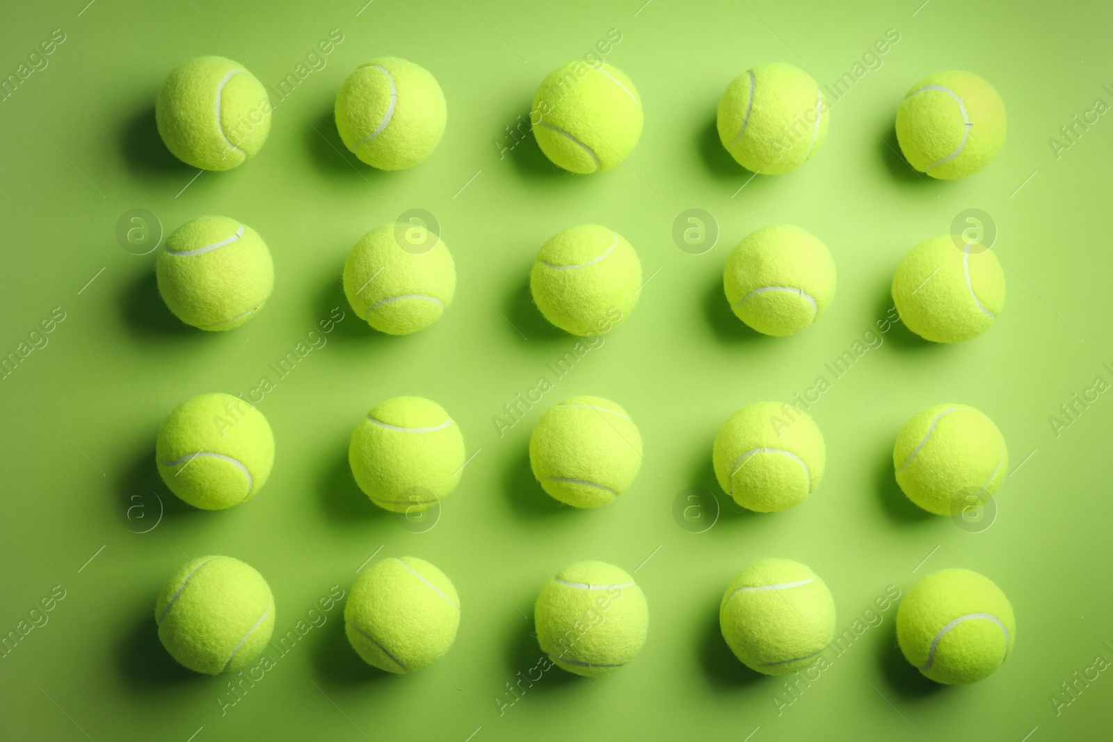 Photo of Tennis balls on green background, flat lay. Sports equipment