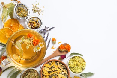 Photo of Freshly brewed tea and dried herbs on white background, top view. Space for text