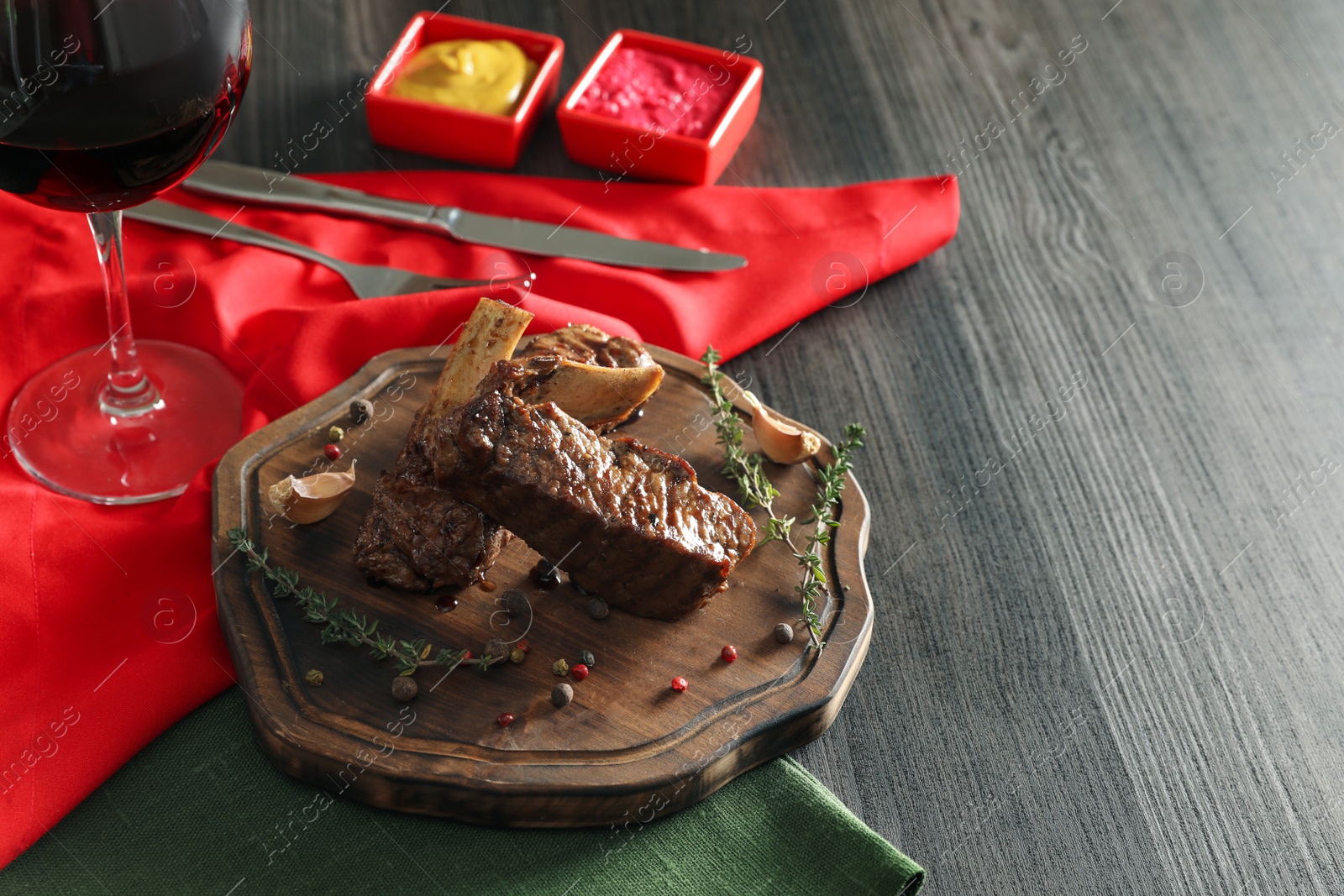 Photo of Delicious roasted ribs served on wooden table