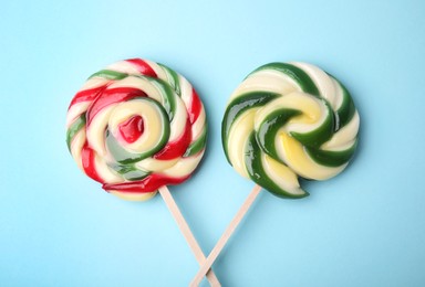 Colorful lollipops on light blue background, flat lay