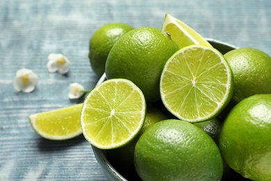 Photo of Bowl with fresh ripe limes on table, closeup