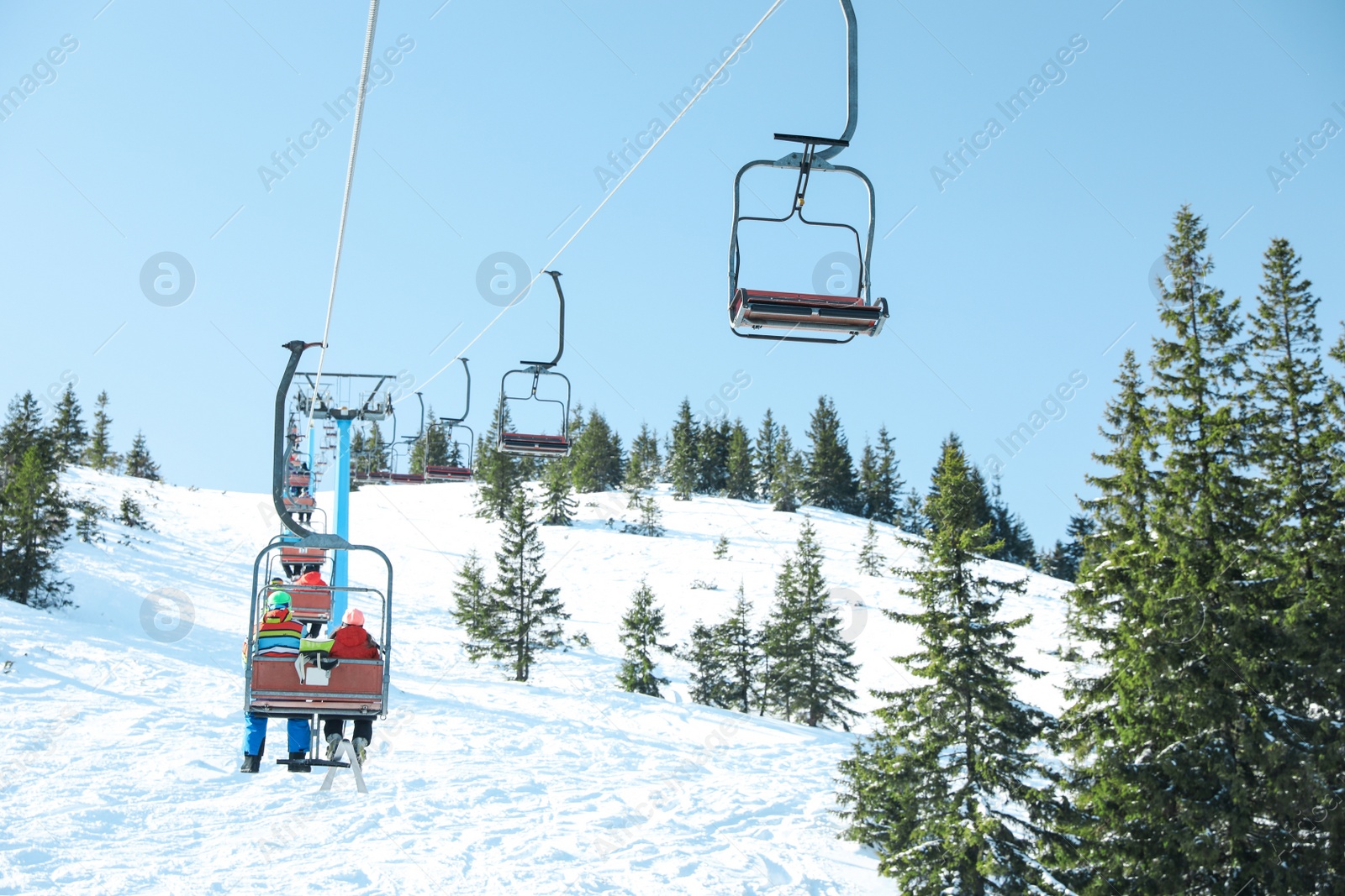 Photo of People using chairlift at mountain ski resort. Winter vacation