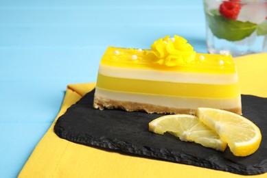 Delicious cheesecake with lemon on light blue wooden table, closeup. Space for text