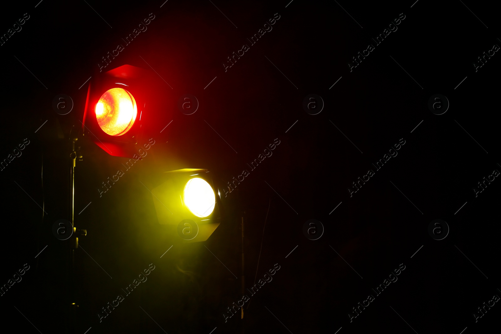 Photo of Bright colorful spotlights and smoke in darkness. Space for text