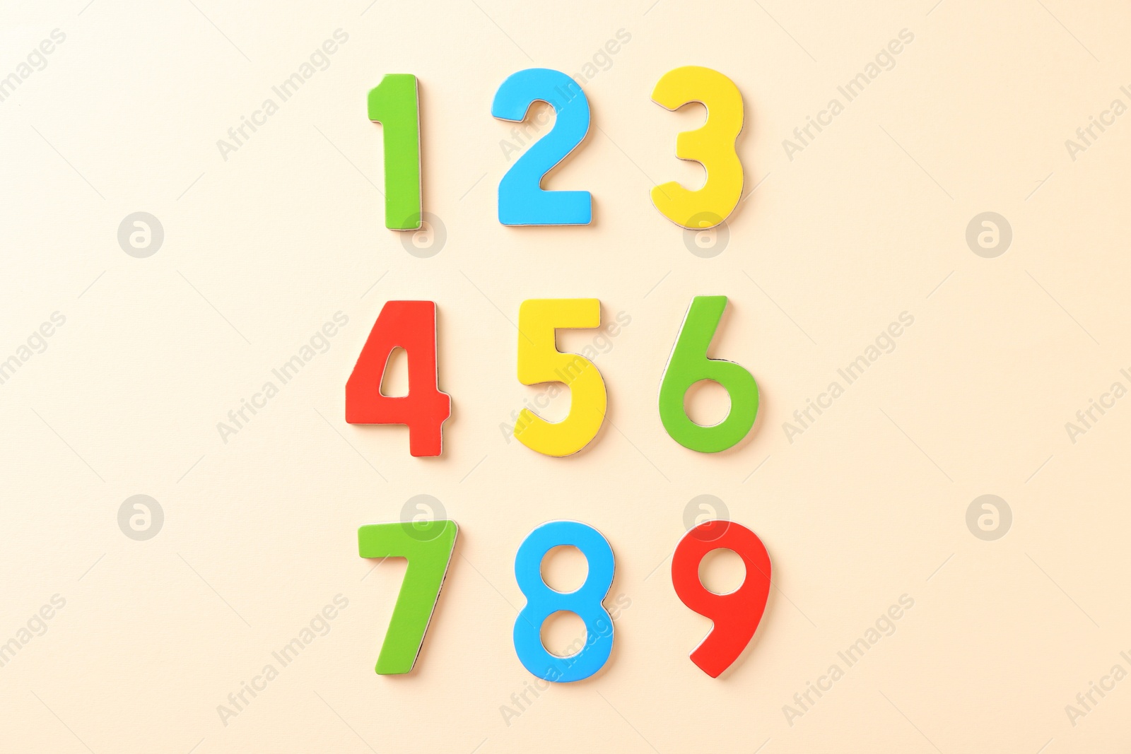 Photo of Colorful numbers on beige background, flat lay