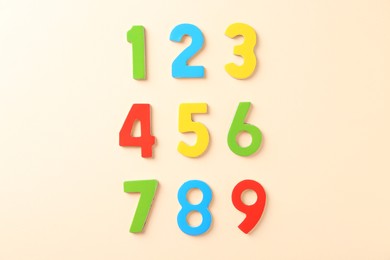 Colorful numbers on beige background, flat lay