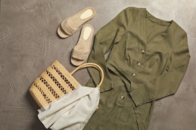 Stylish dress, bag and shoes on grey stone background, flat lay