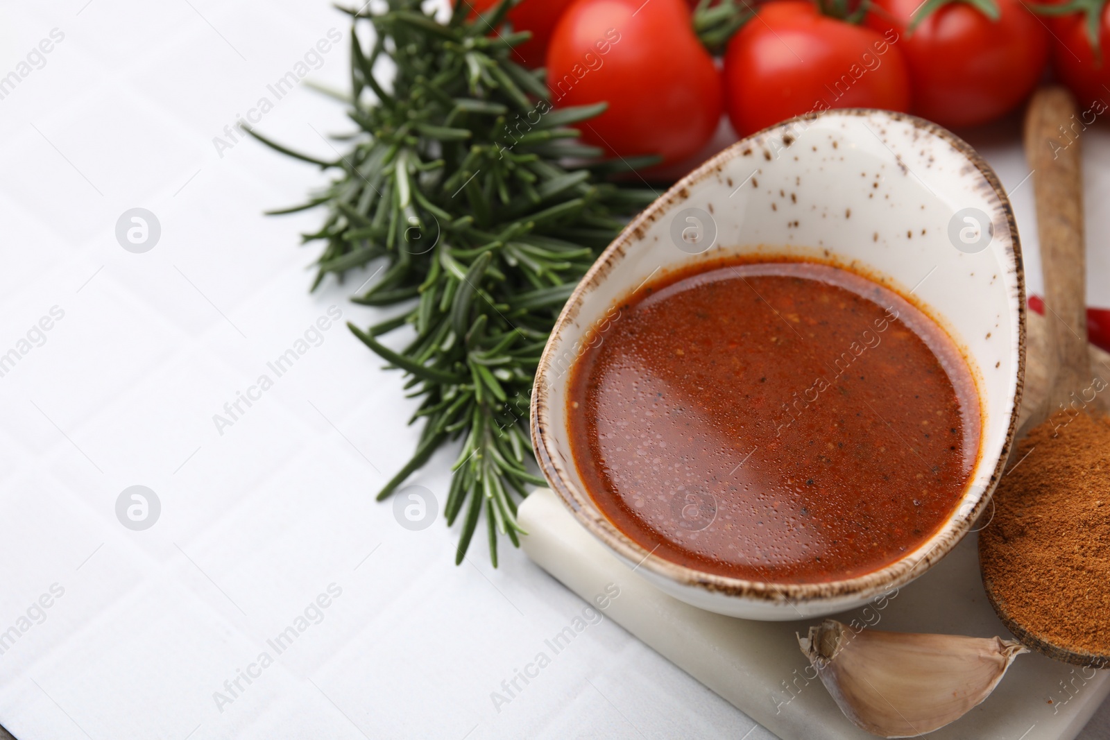 Photo of Fresh marinade and ingredients on white tiled table. Space for text