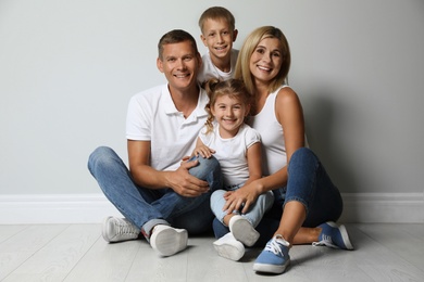 Photo of Happy family with children near grey wall