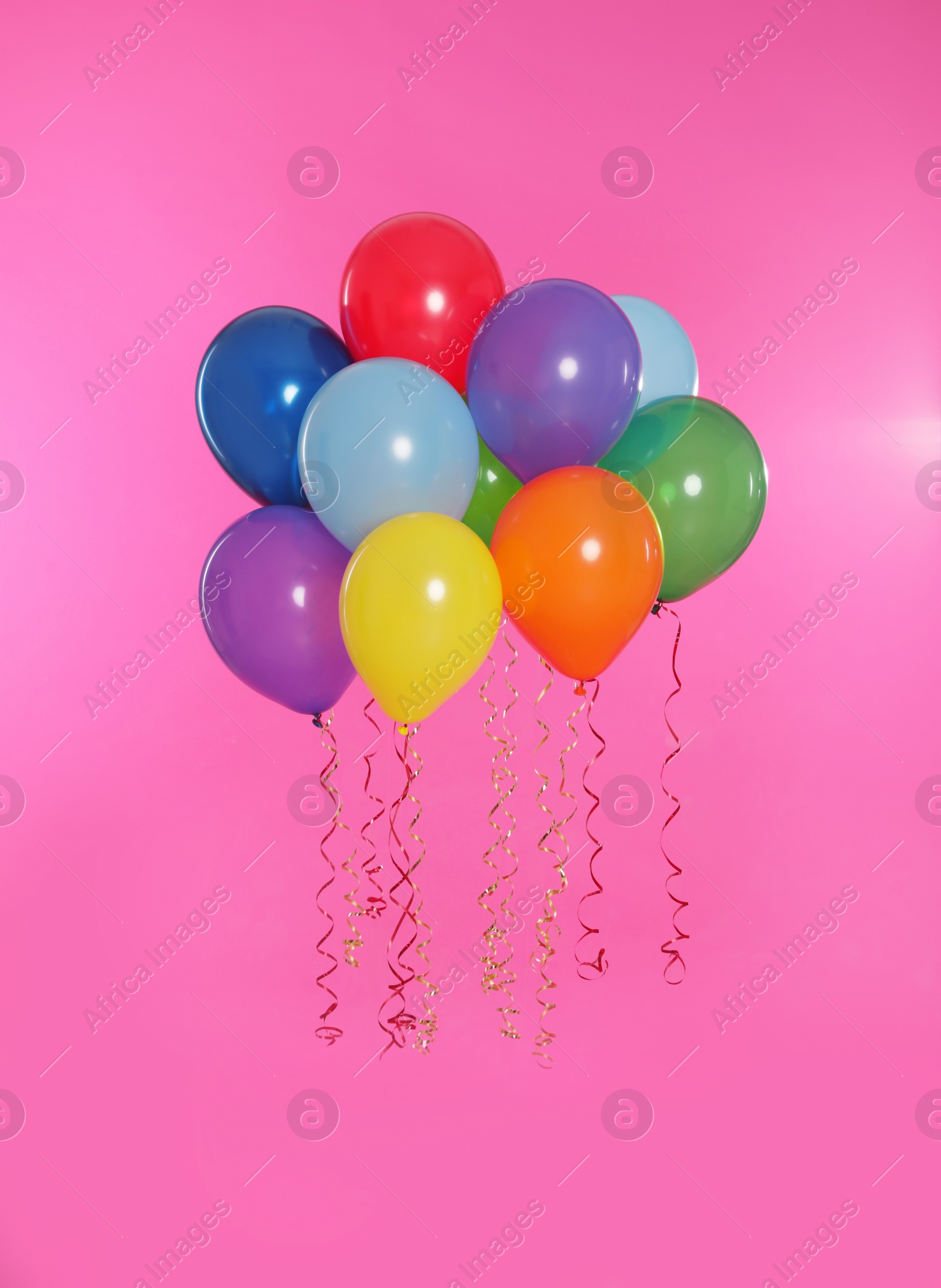 Photo of Many bright balloons floating on color background