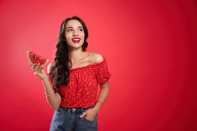 Photo of Beautiful young woman with watermelon on red background. Space for text