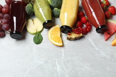 Photo of Bottles of delicious juices and fresh fruits on marble table. Space for text