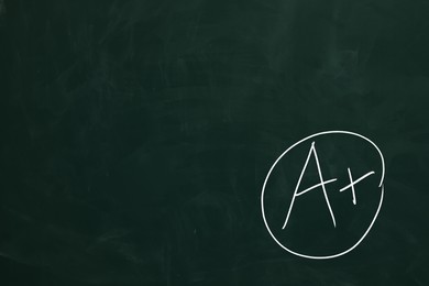 School grade. Letter A with plus symbol on green chalkboard