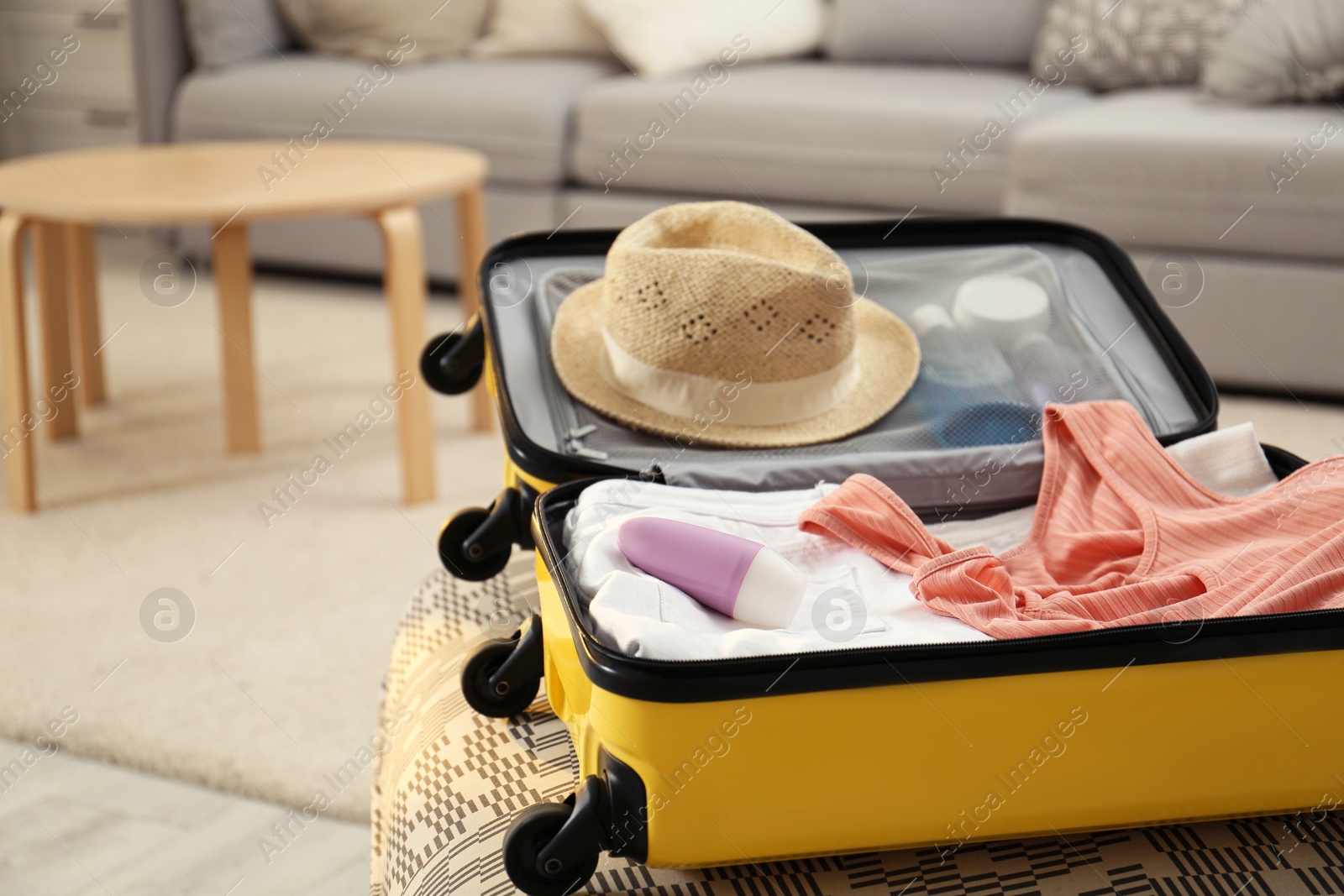 Photo of Suitcase with deodorant and clothes at home