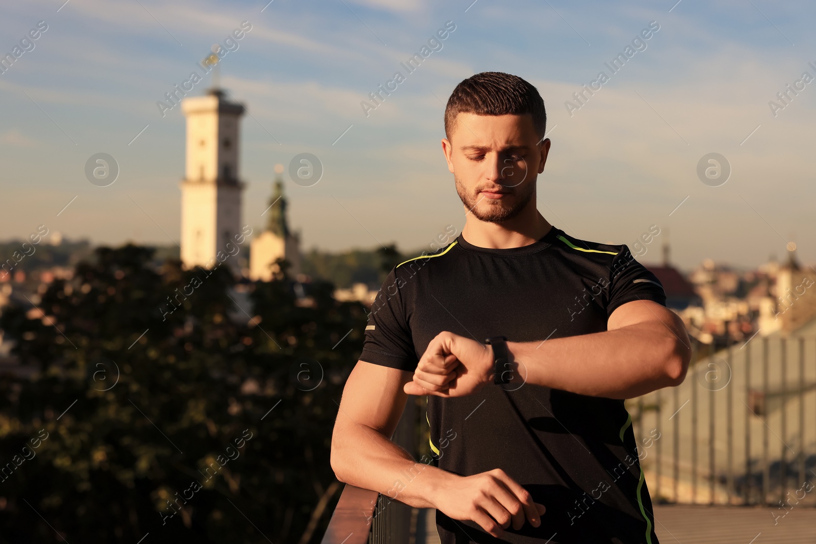 Photo of Attractive serious man checking pulse after training outdoors. Space for text