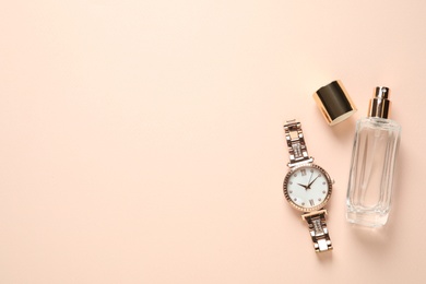 Photo of Luxury wrist watch and perfume on beige background, flat lay. Space for text