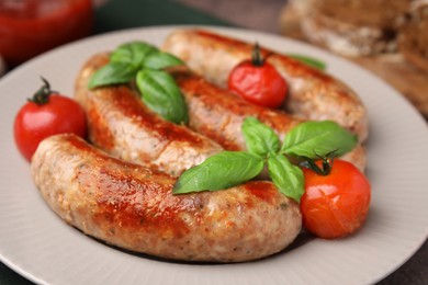 Photo of Plate with tasty homemade sausages, basil leaves and tomatoes, closeup