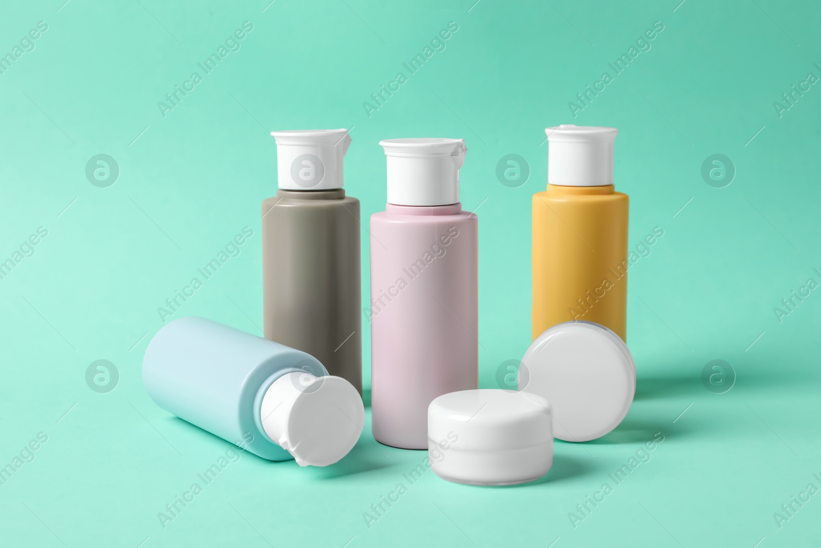 Photo of Cosmetic travel kit on turquoise background. Bath accessories