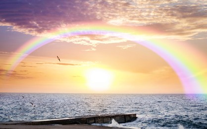 Image of Beautiful view of colorful rainbow in sky over sea