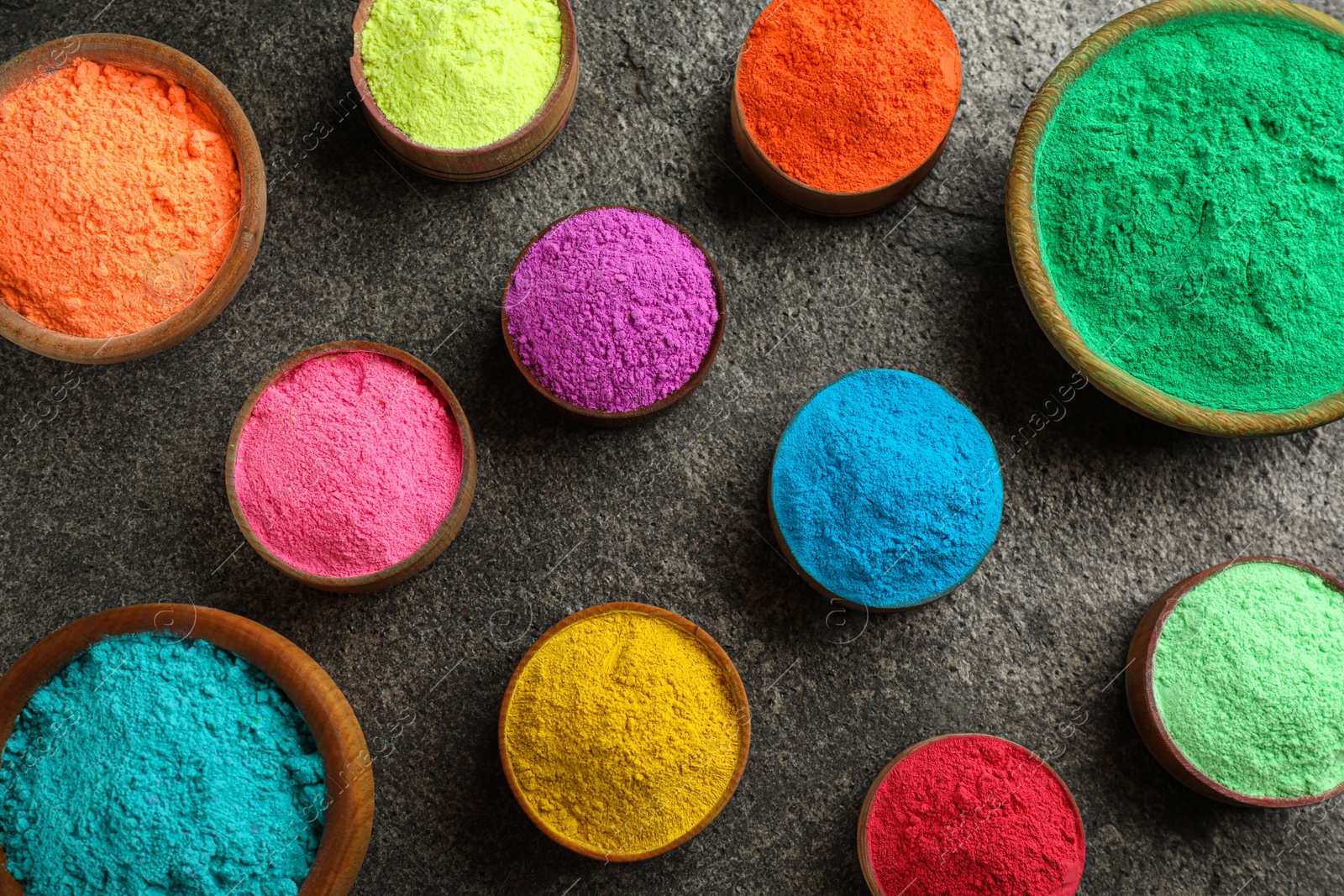 Photo of Colorful powder dyes on grey background, flat lay. Holi festival