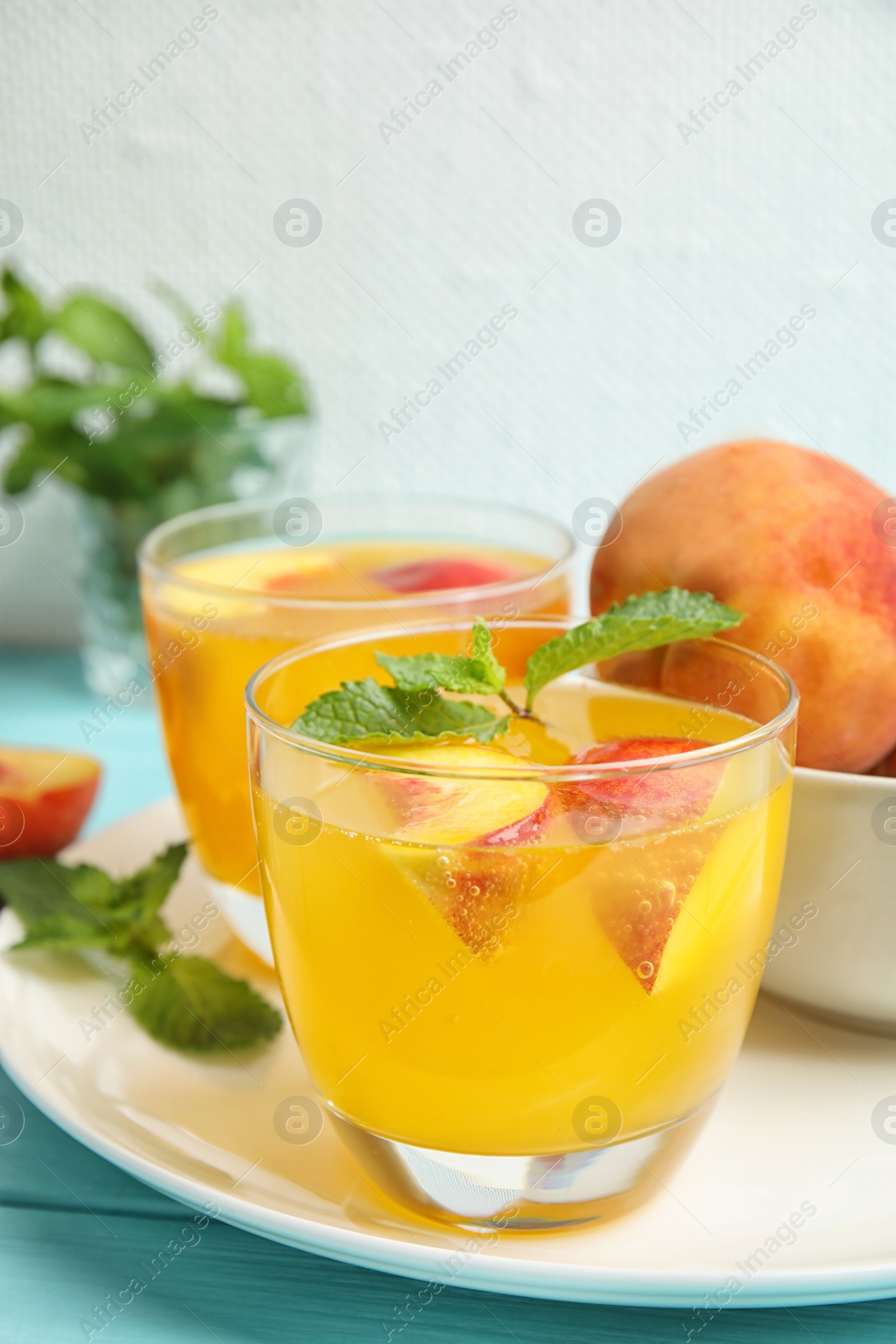 Photo of Tasty peach cocktail in glasses on table. Refreshing drink