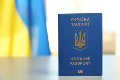 Photo of Ukrainian travel passport on table against blurred background, space for text. International relationships
